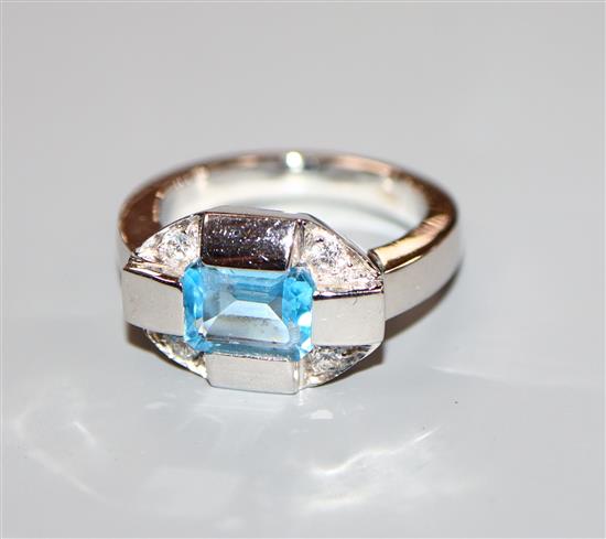 A stylish 750 white metal, blue topaz and diamond five stone dress ring, size N.